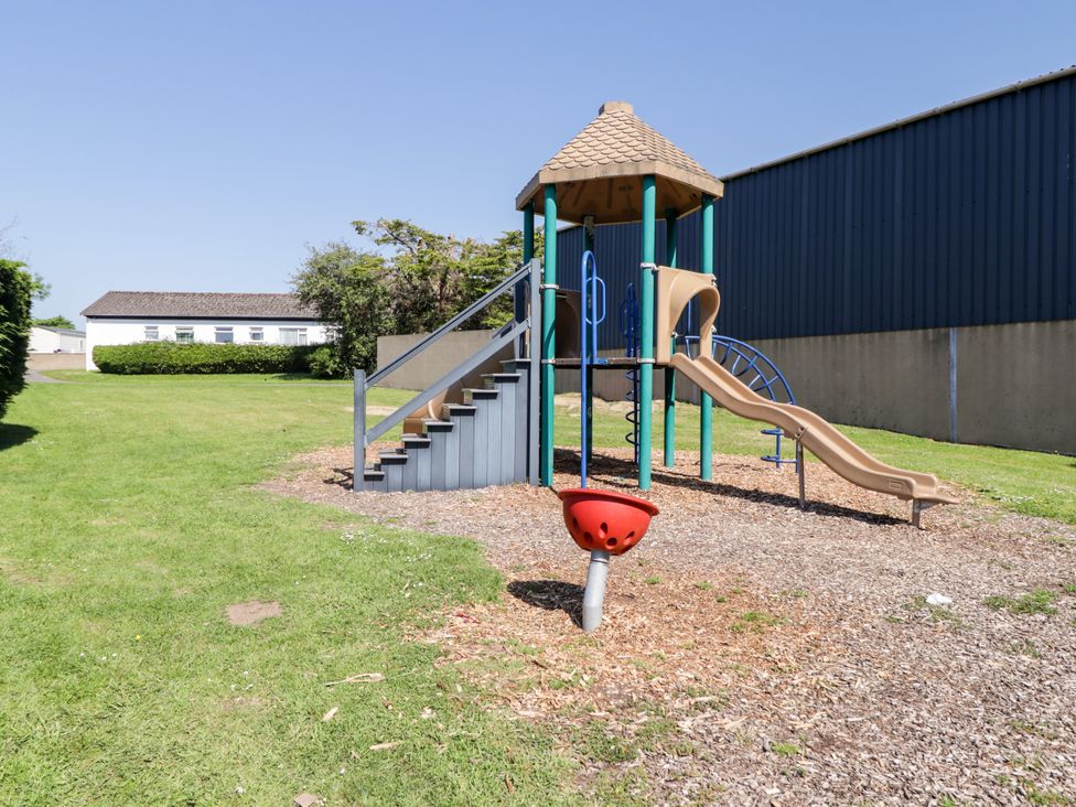 A playground with a slide and climbing structure at Cottage 1 in Tenby