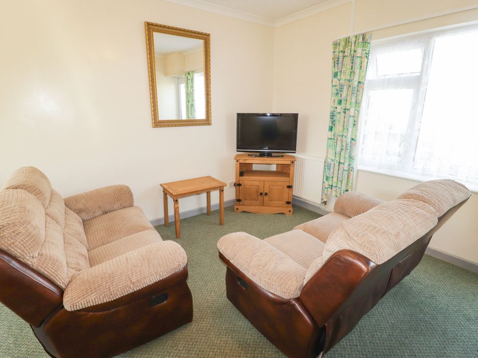 A living room with sofa and television at Cottage 3 in Tenby