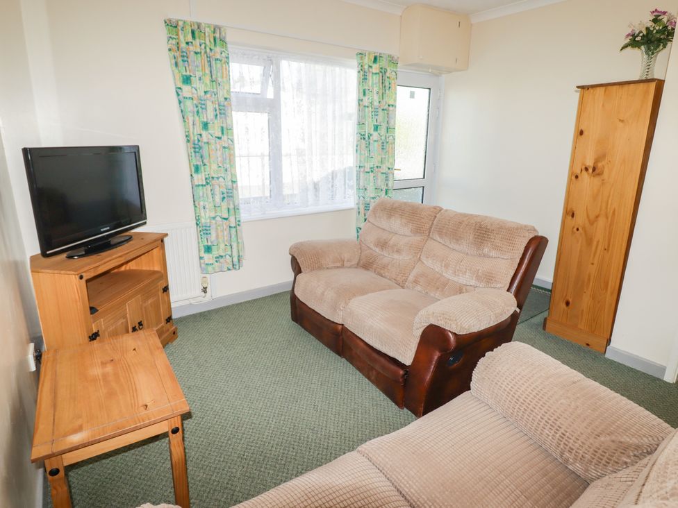 A living room with a television and seating at Cottage 3 in Tenby