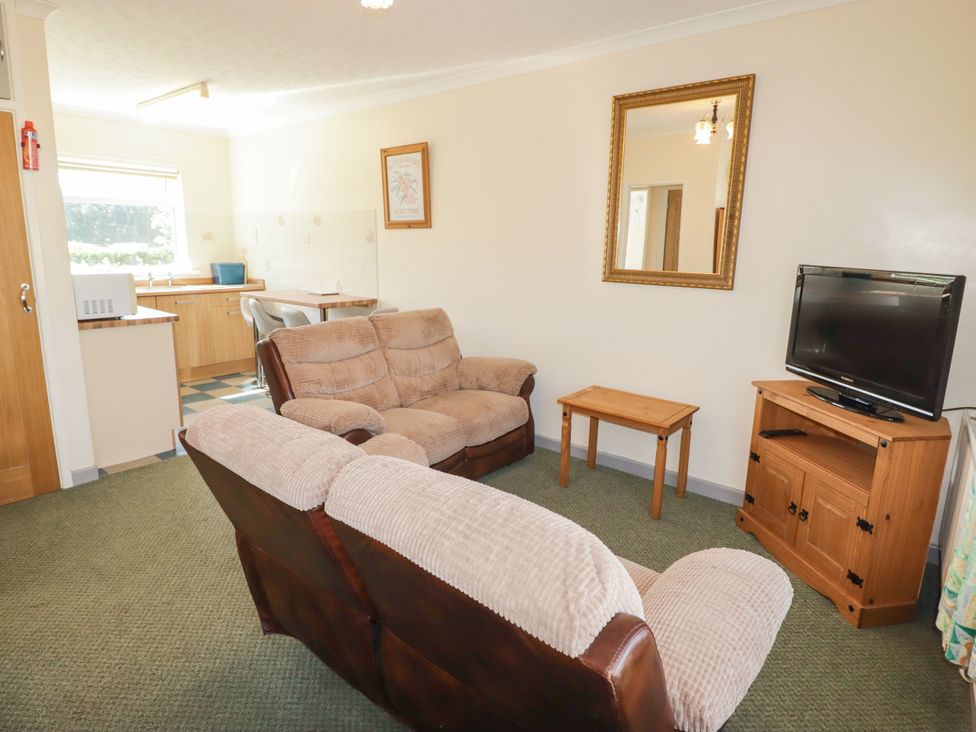 A living room with a couch and television at Cottage 3 in Tenby