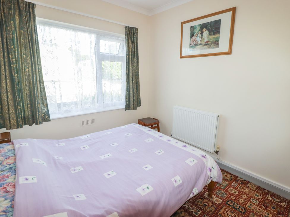 A bedroom with a bed and window at Cottage 3 in Tenby