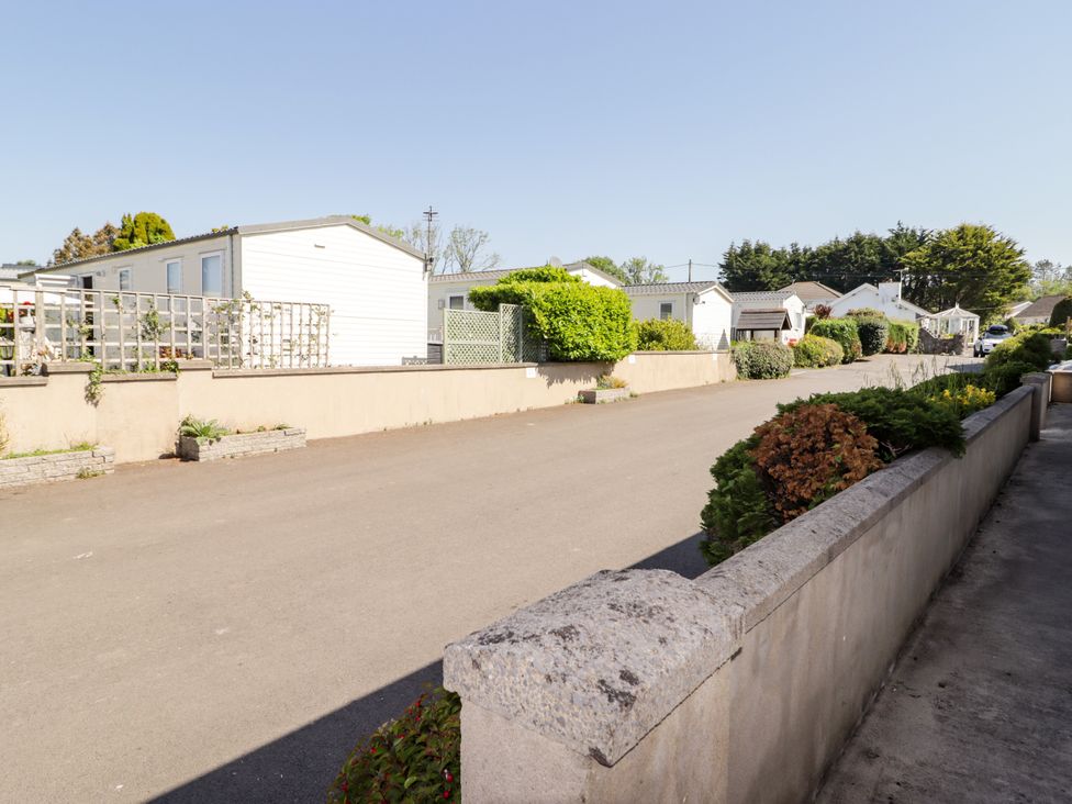 A street with mobile homes and greenery at Cottage 3 in Tenby