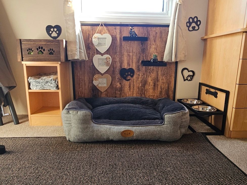 A dog bed with a storage box and food bowls at Balwen Nercwys near Mold