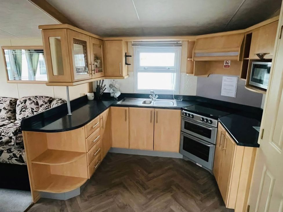 A kitchen with cabinets and a stove at Balwen in Nercwys near Mold