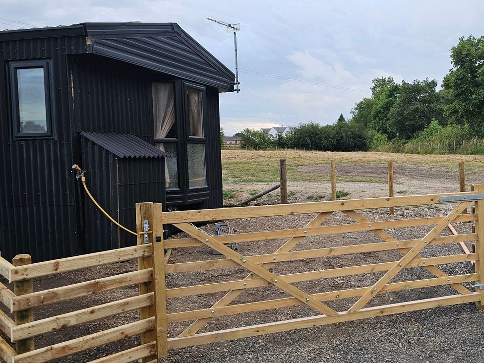 A house with a wooden gate and fence at Balwen in Nercwys near Mold