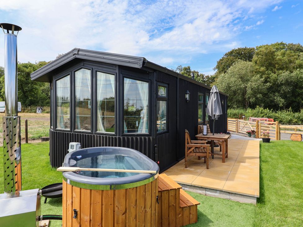 An outdoor area featuring a hot tub and seating at Balwen in Nercwys near Mold