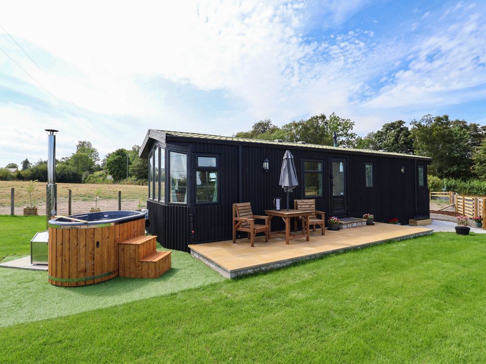 An outdoor area with a hot tub and seating in Balwen Nercwys near Mold