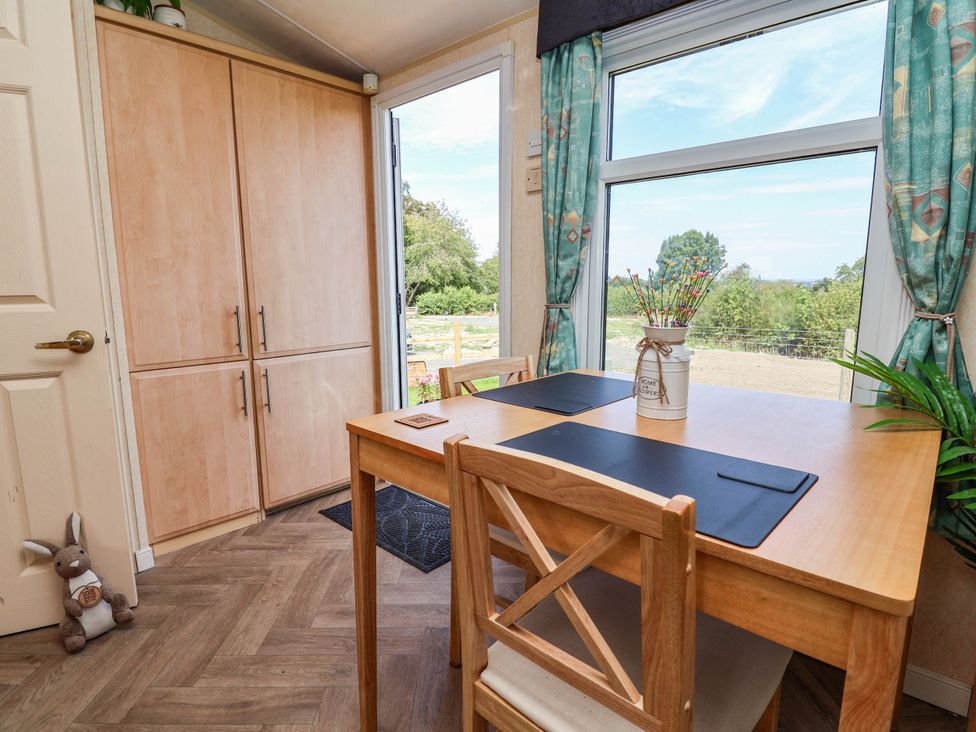A dining room with a table and chairs at Balwen in Nercwys near Mold