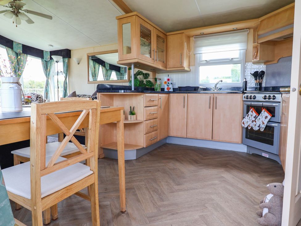 A kitchen with wood cabinets and appliances at Balwen in Nercwys near Mold