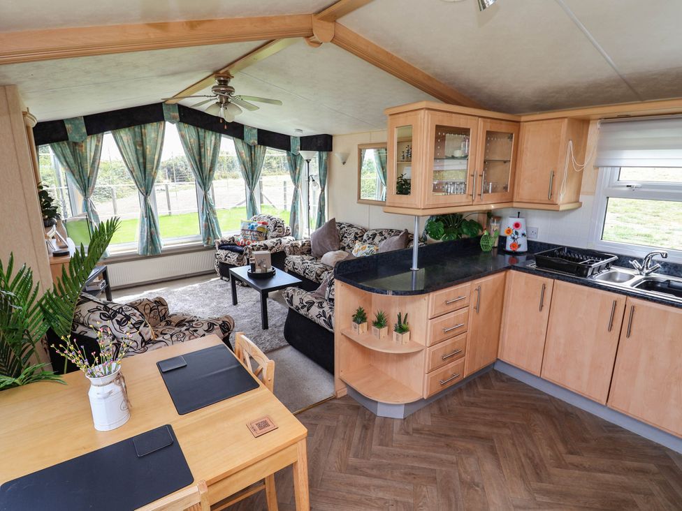 A living room with a kitchen area and seating at Balwen Nercwys near Mold