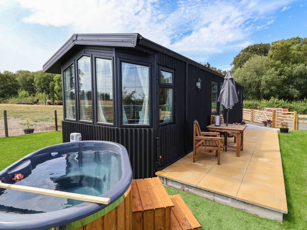 A hot tub and outdoor seating area at Balwen in Nercwys near Mold