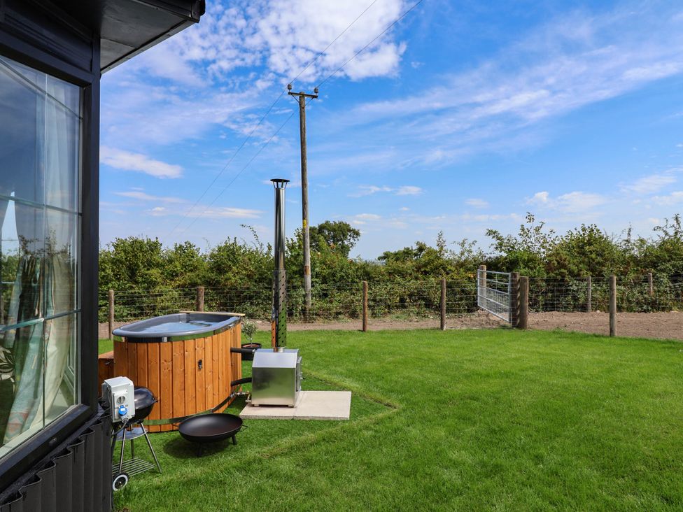 A garden with a hot tub and a metal stove at Balwen Nercwys near Mold