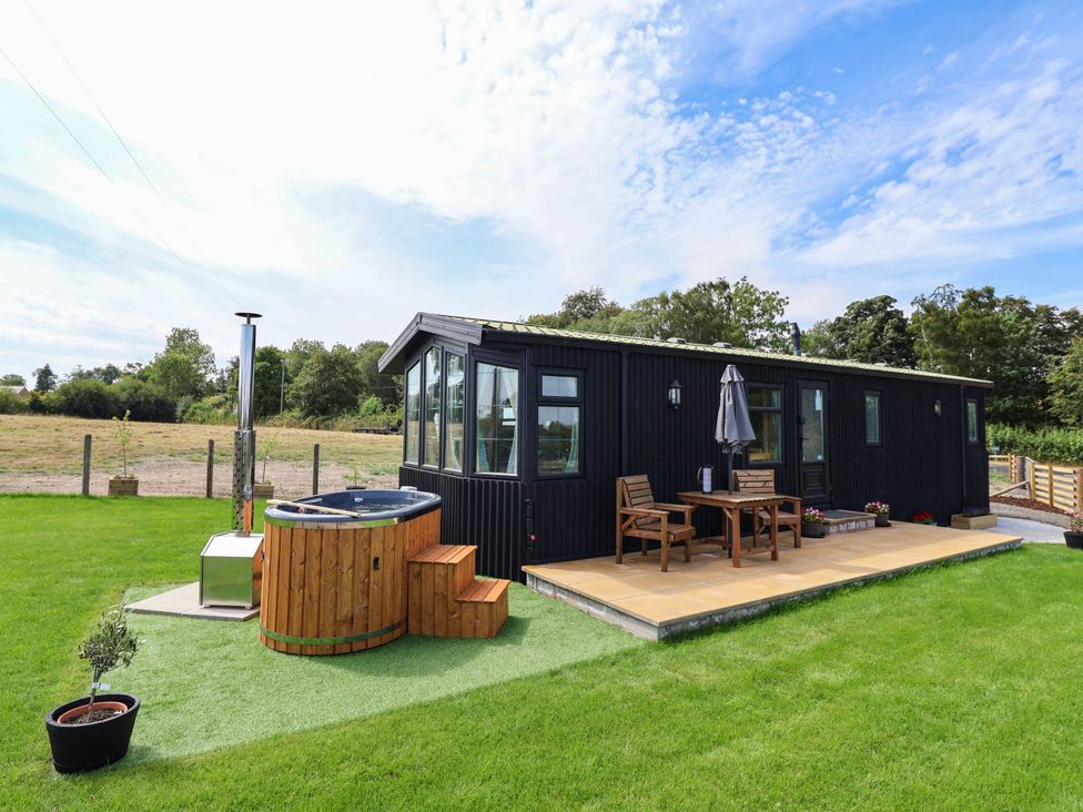 An outdoor area with a hot tub and seating at Balwen Nercwys near Mold