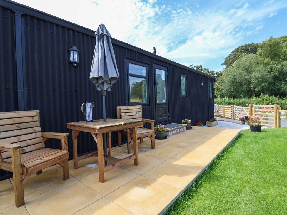 A patio area with a table and chairs at Balwen in Nercwys near Mold