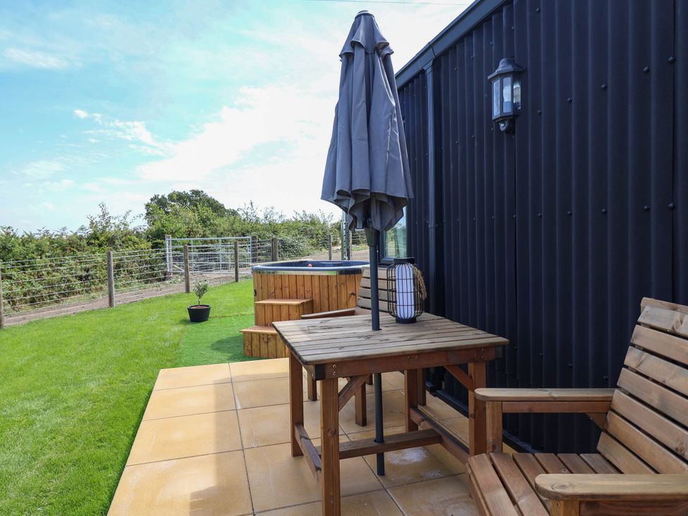 An outdoor area with a table and umbrella at Balwen in Nercwys near Mold