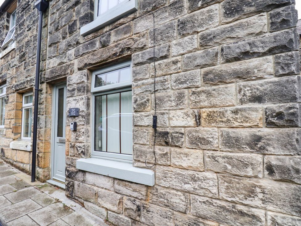An exterior view of a stone house with a door and windows at The Snug Glaisdale