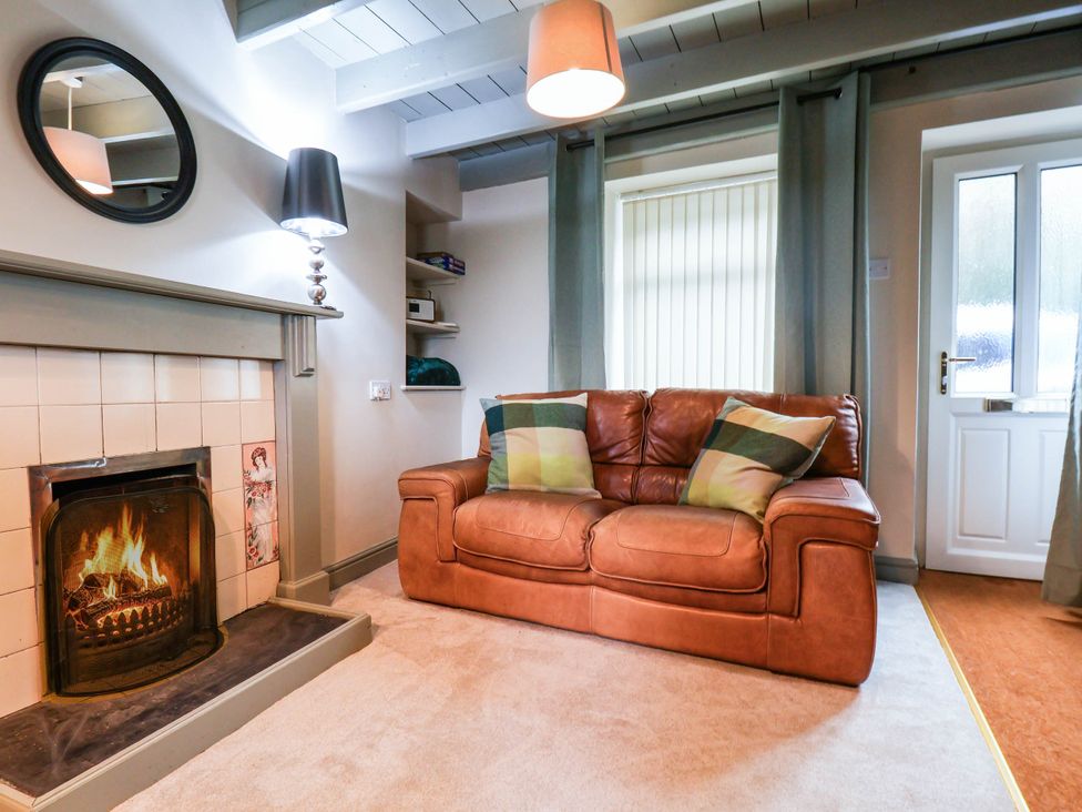 A living room with a sofa and fireplace at The Snug Glaisdale