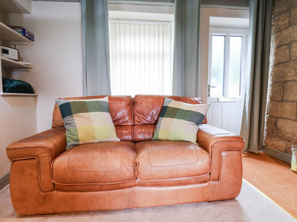 A sofa with cushions near a door at The Snug Glaisdale