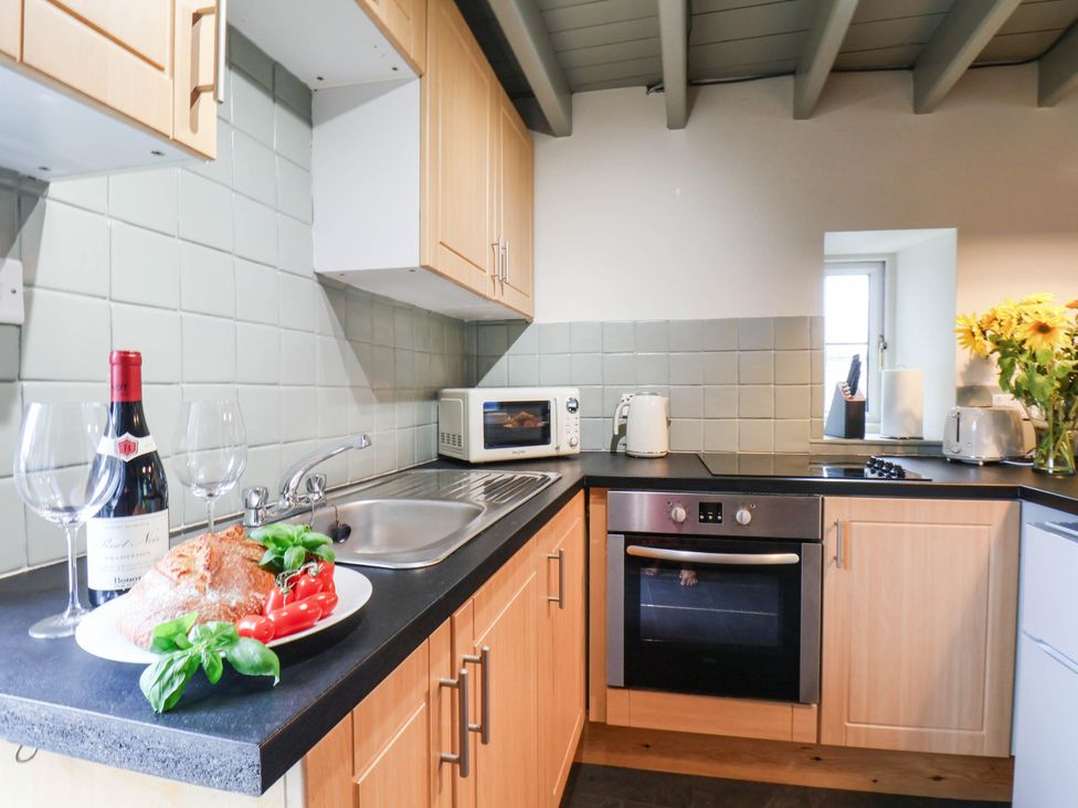 A kitchen with sink oven and microwave at The Snug Glaisdale