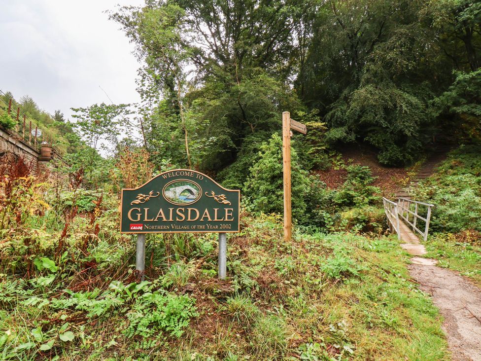 A welcome sign for Glaisdale with a pathway and bridge at Glaisdale