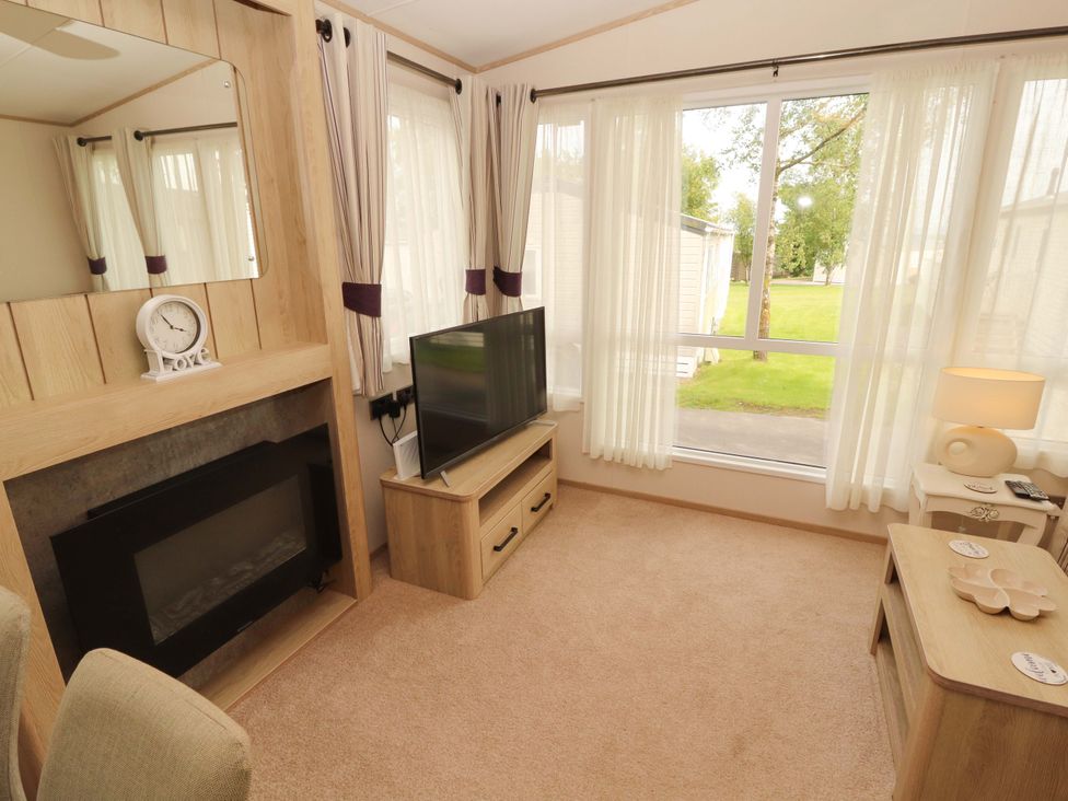 A living room with a television and a lamp at Caravan