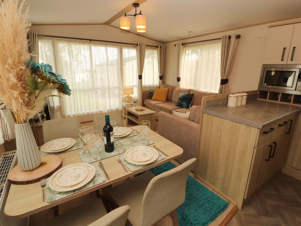 A dining area with a table set for dinner and a sofa at Caravan 