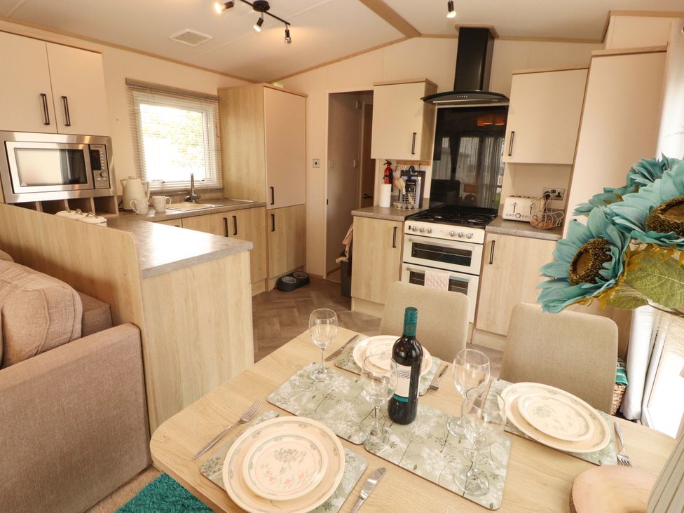 A kitchen and dining area with a dining table set at Caravan