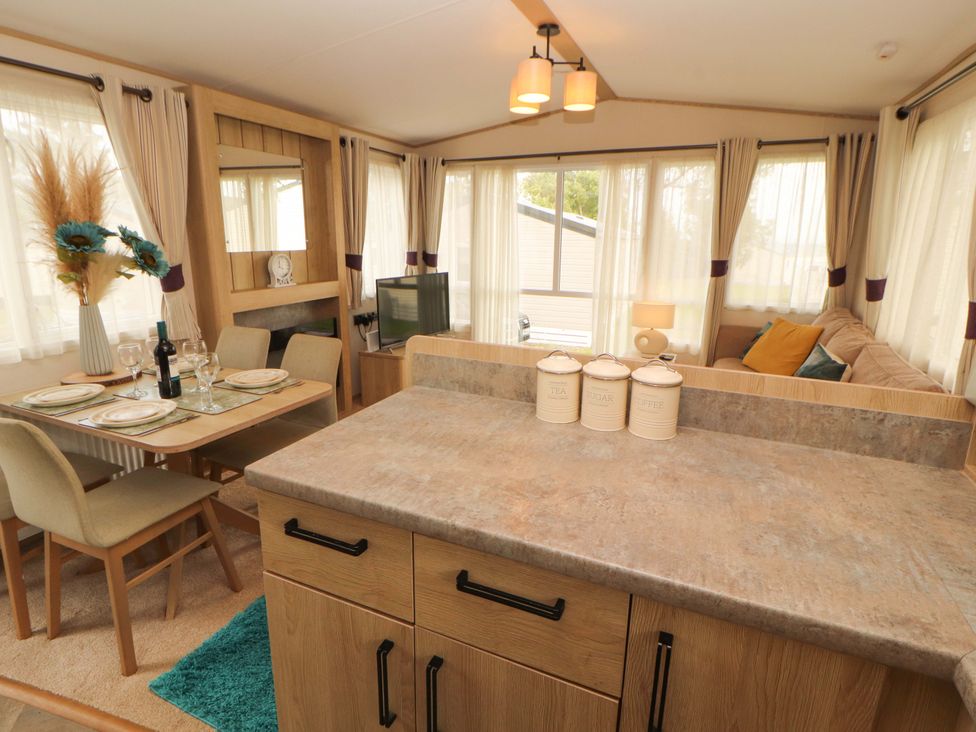 A living room with a dining area and television at Caravan