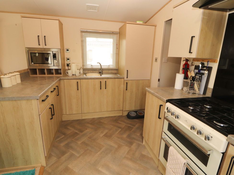 A kitchen with cabinets and appliances at Caravan