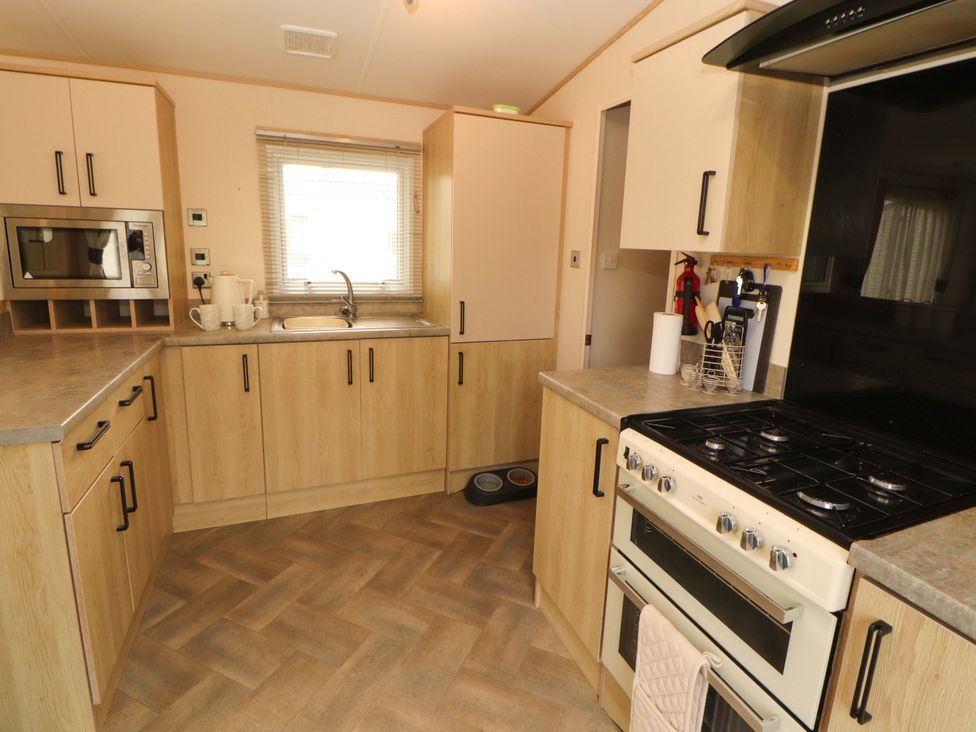 A kitchen with a sink and gas stove in a Caravan