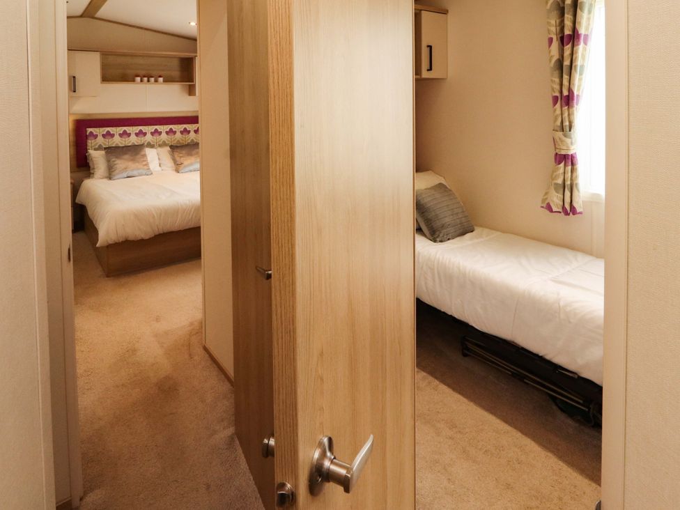A bedroom with a large bed and a single bed at Caravan