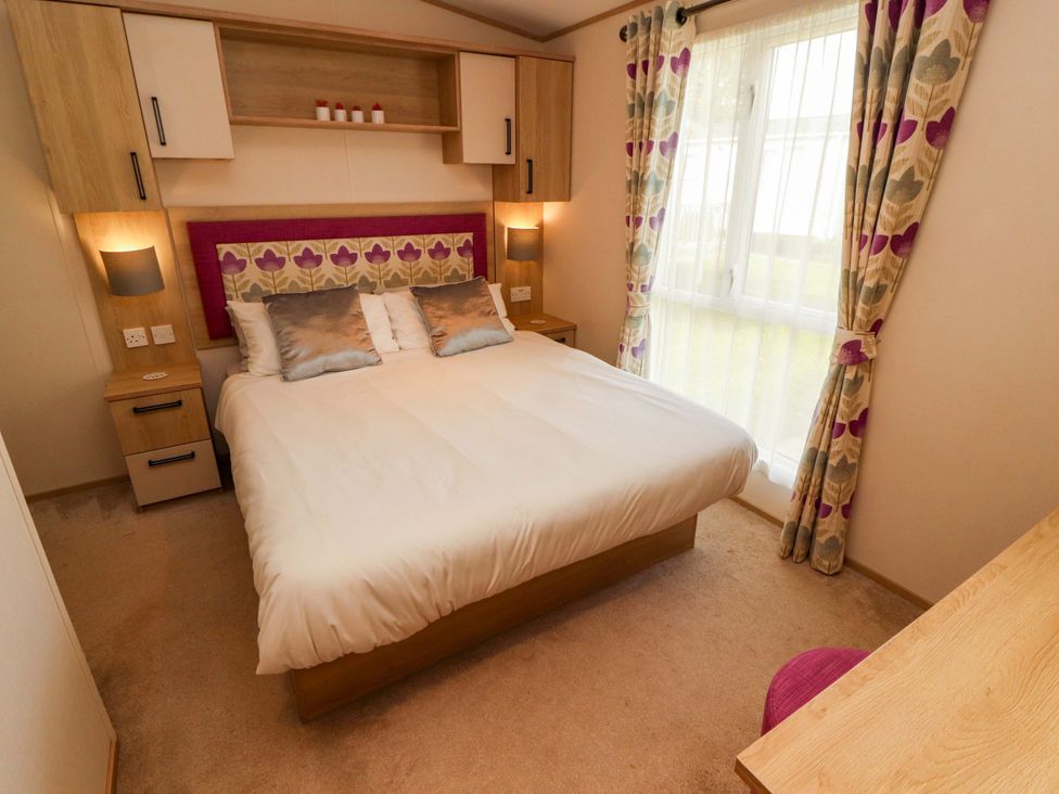 A bedroom with a bed and nightstands at Caravan
