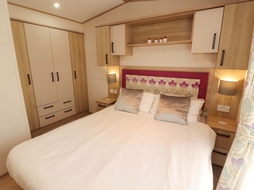 A bedroom with a bed and wardrobe at Caravan
