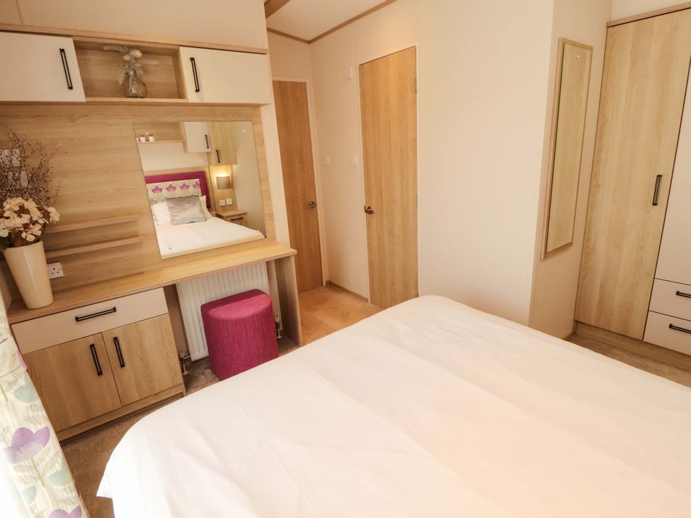 A bedroom with a bed and dresser at Caravan