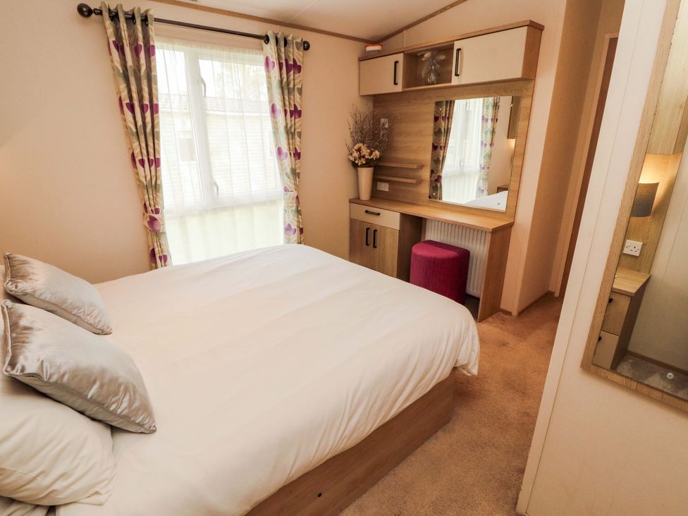 A bedroom with a bed and dressing table at Caravan