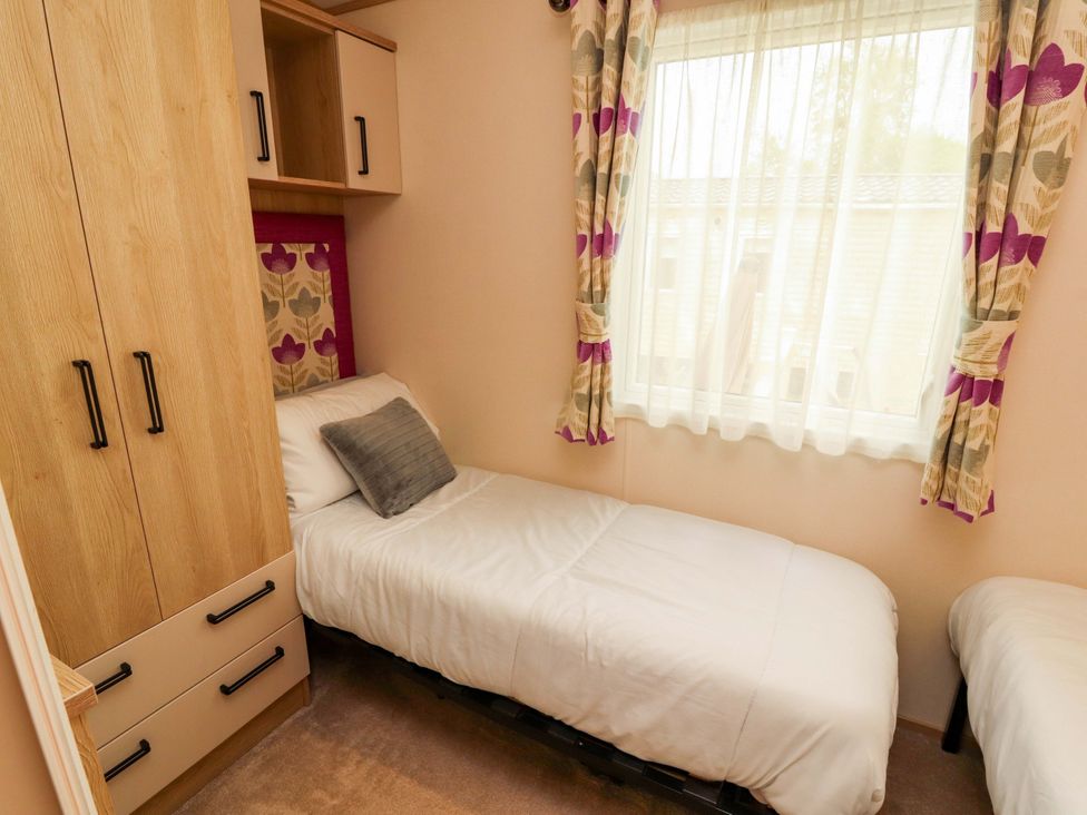 A bedroom with a single bed and wardrobe at Caravan