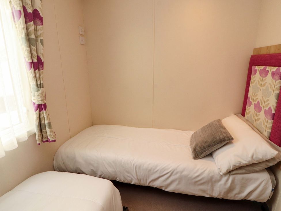 A bedroom containing two beds and a window at Caravan