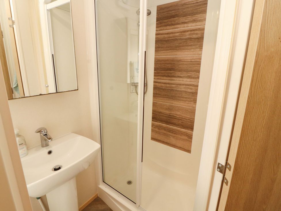 A bathroom with a shower and sink at Caravan