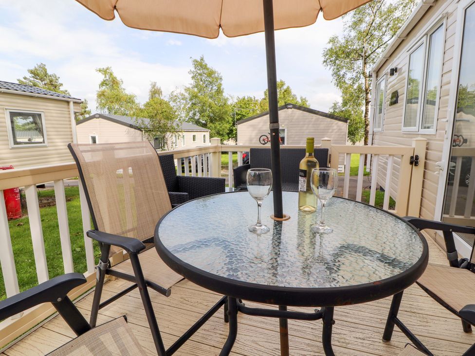 A table with chairs and wine on a deck at Caravan