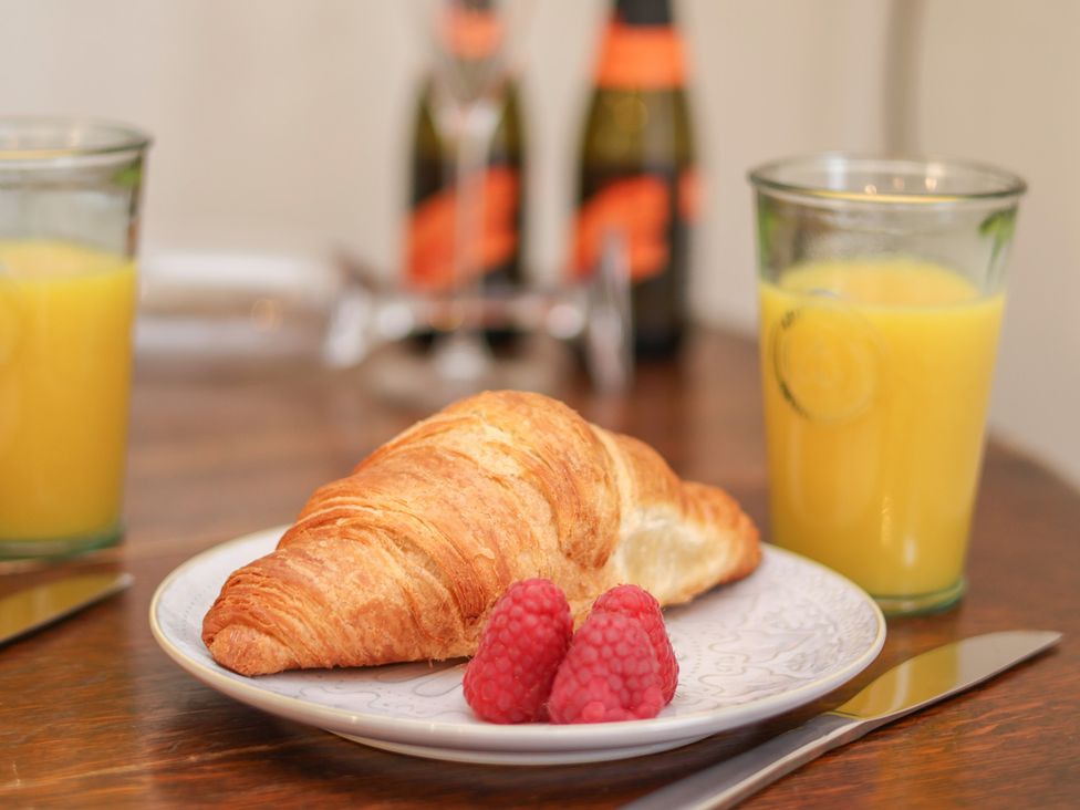 A croissant and raspberries with orange juice on a table at 4 Studley Terrace, Whitby