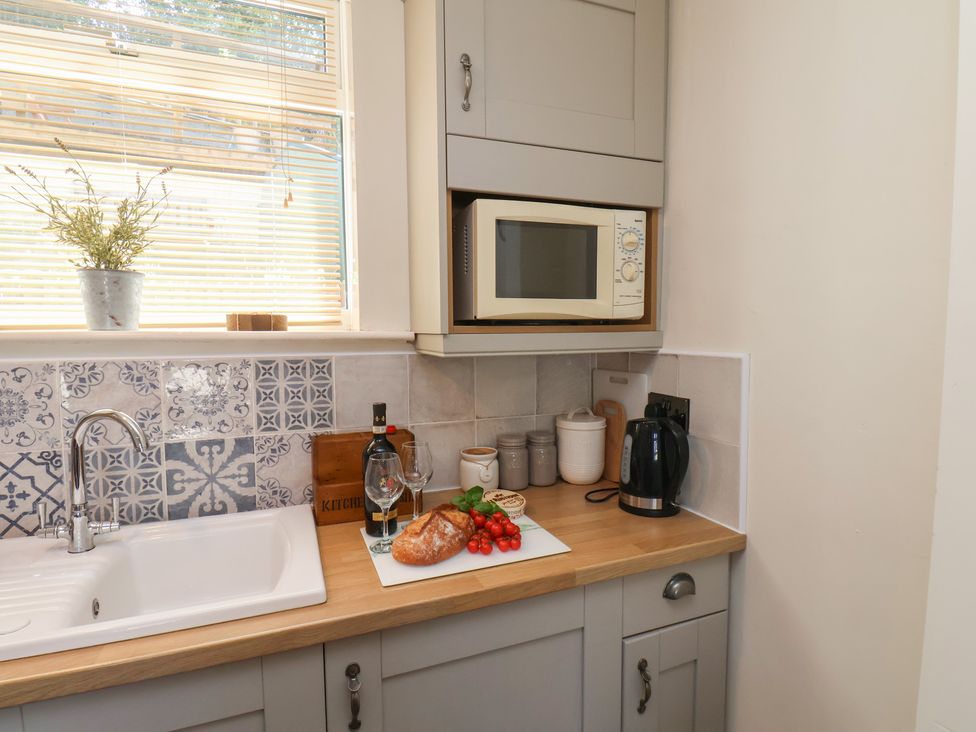 A kitchen with a sink and microwave at 4 Studley Terrace in Whitby