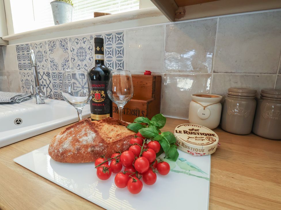 A kitchen counter with wine, bread, tomatoes, and cheese at 4 Studley Terrace Whitby
