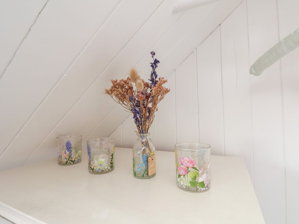 A shelf with glass jars filled with dried flowers at 4 Studley Terrace in Whitby