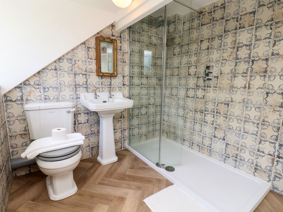 A bathroom with a shower, sink, and toilet at 4 Studley Terrace Whitby
