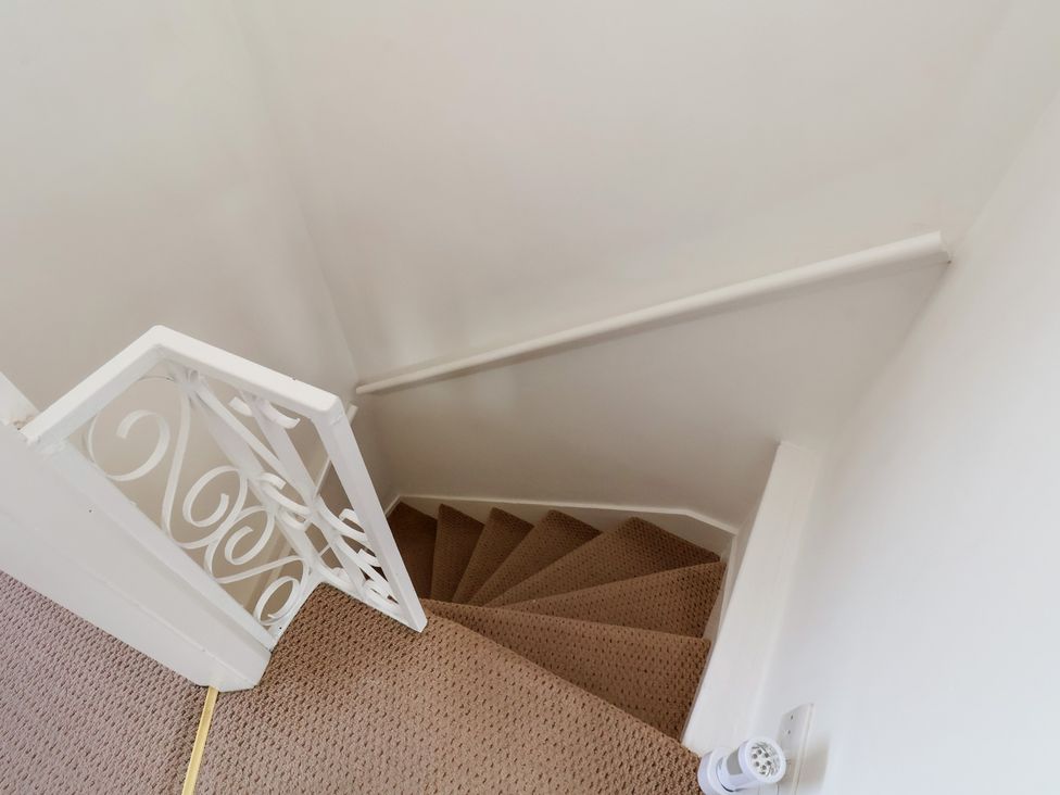 A staircase with a handrail and carpet at 4 Studley Terrace in Whitby