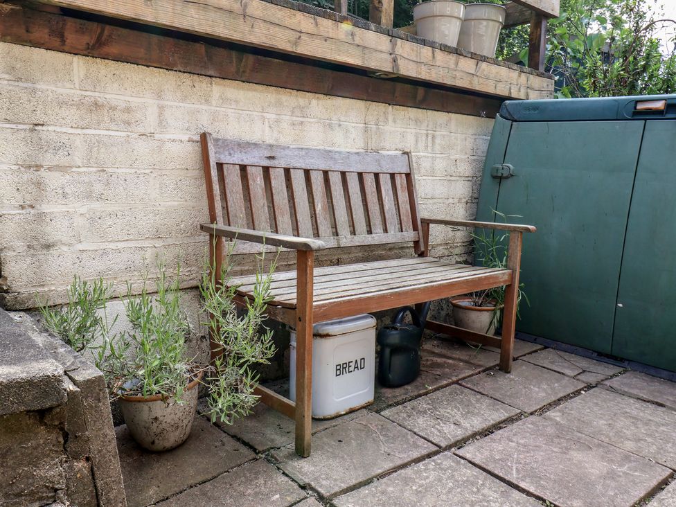 A garden with a wooden bench and planters at 4 Studley Terrace in Whitby
