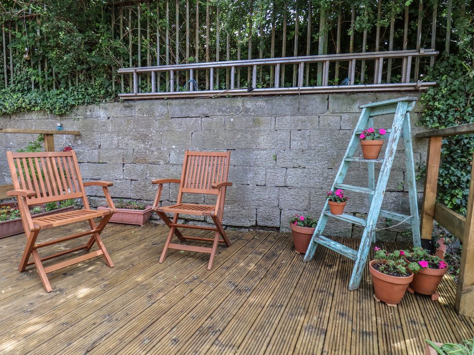 A garden with wooden chairs and potted plants at 4 Studley Terrace in Whitby