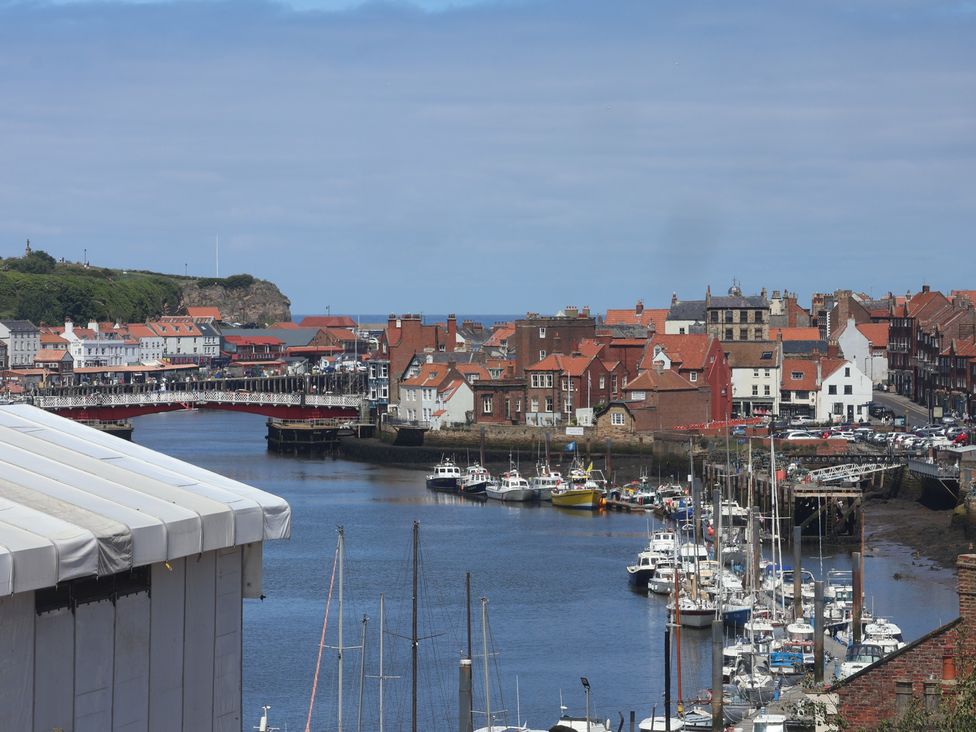 A harbor with boats and buildings at 4 Studley Terrace in Whitby