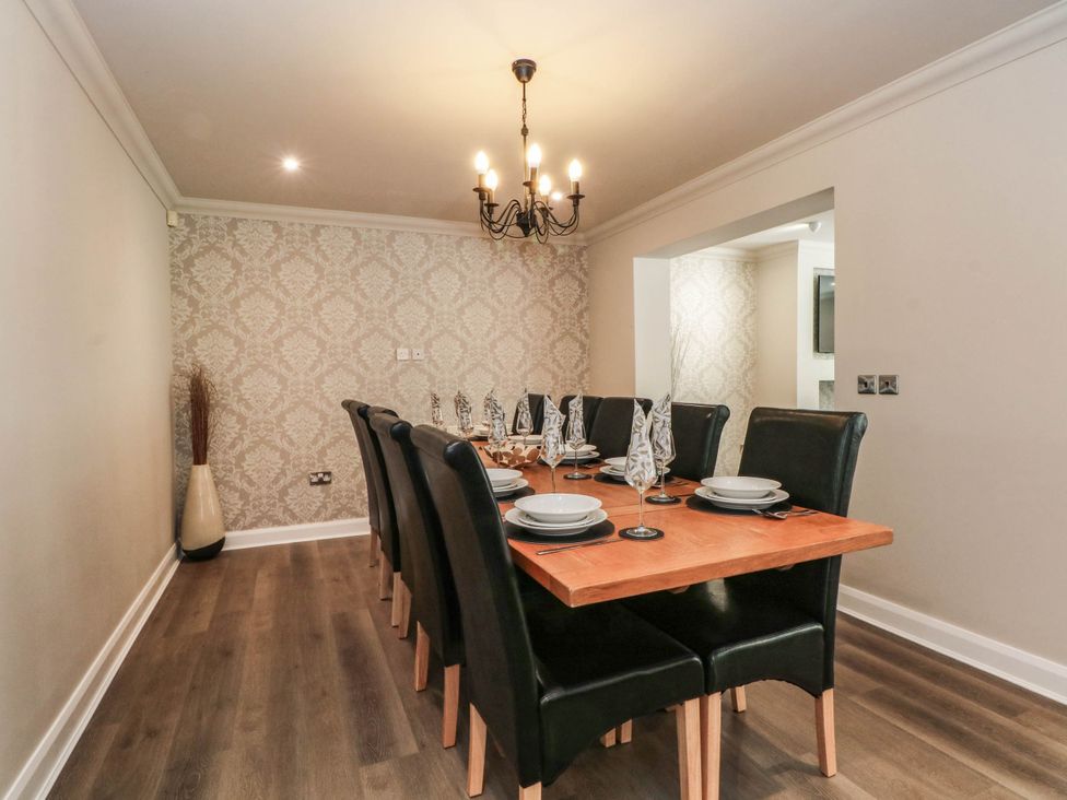 A dining room with a large table and black chairs at The Ferns in Kirkham