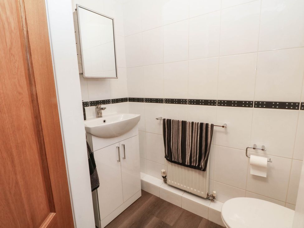 A bathroom with a sink, mirror, and toilet at The Ferns in Kirkham